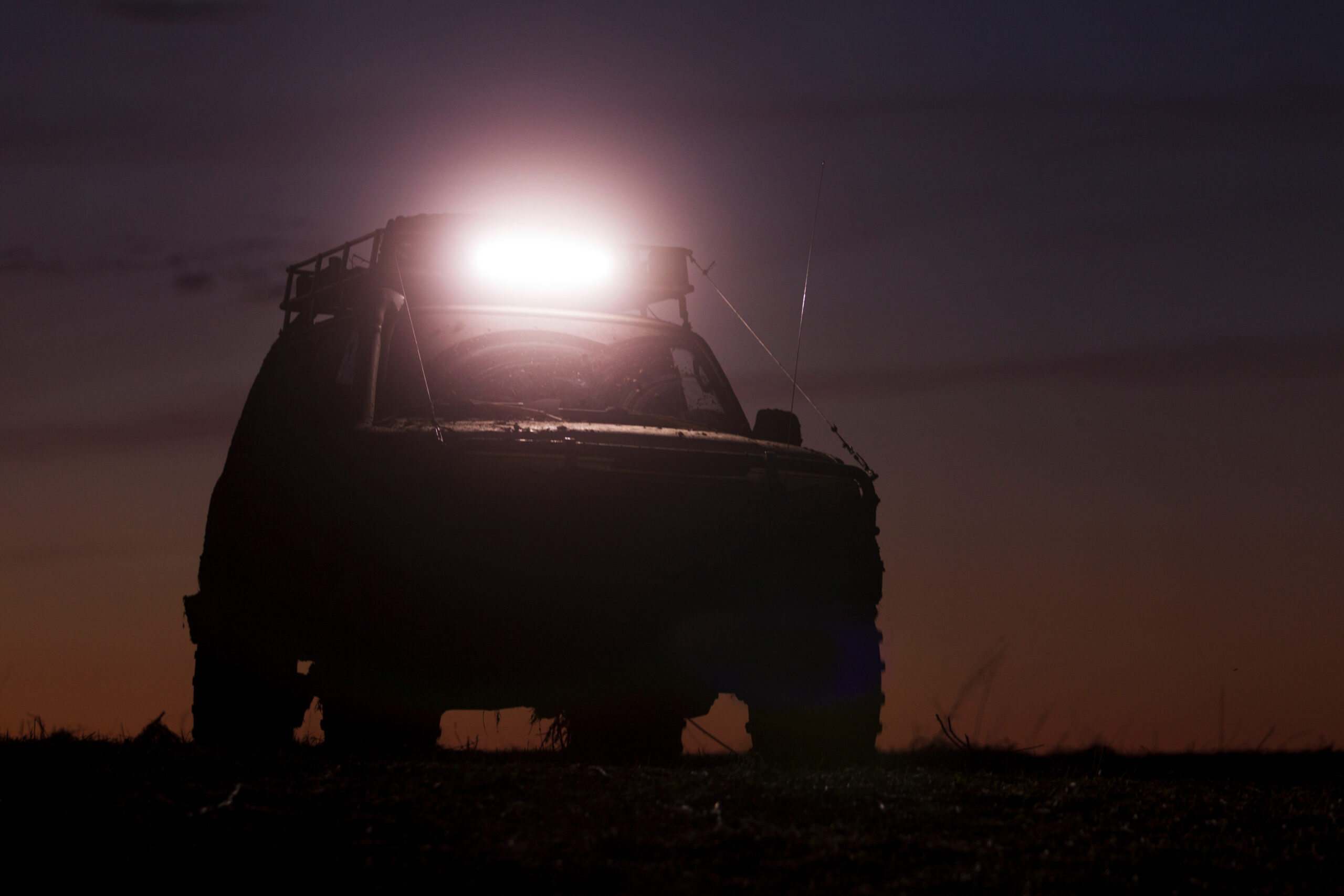 SUV silhouette on sunset sky background